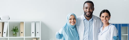 Preview: African american doctor hugging smiling colleagues in clinic, banner