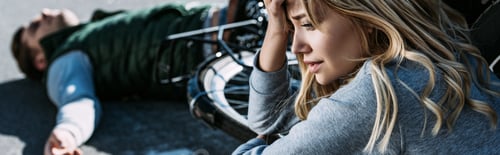 Preview: scared young woman crying near car after traffic collision with cyclist