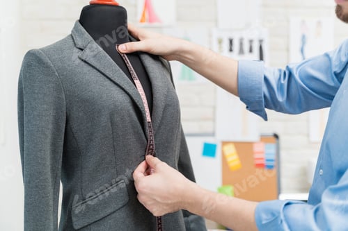 Preview: Young male tailor measuring neck length at atelier