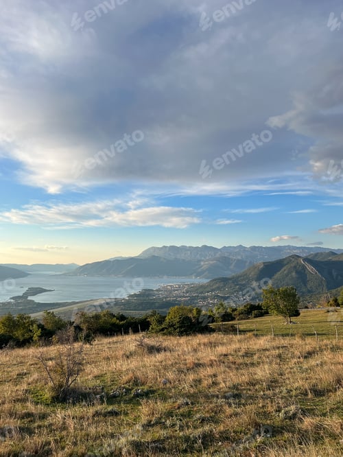 Preview: Green meadow above the sea surrounded by a mountain range