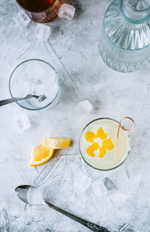 Preview: Citrus cocktail with lemon juice and decorated with lemon peel on the table.