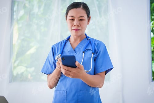 Preview: An Asian female nurse stands by a research desk in a hospital, consulting a doctor to verify