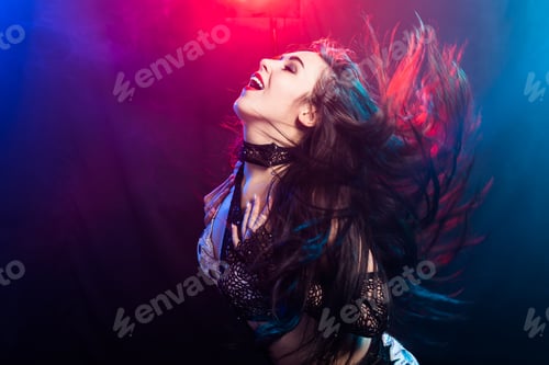 Preview: Young woman belly dancer in exotic dress with gold, dancing tribal fusion dance in studio