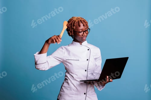 Preview: Confused cooker looking dish instructions on laptop screen