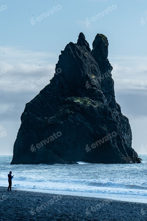 Preview: Massive cliff against the background of the sky. Black Sand Beach Reynisfjara, Iceland.