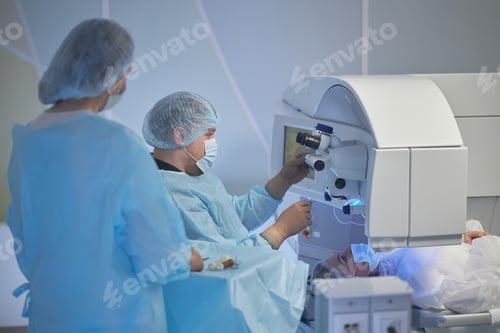 Preview: Female Patient Undergoing Eye Surgery Performed by Medical Team
