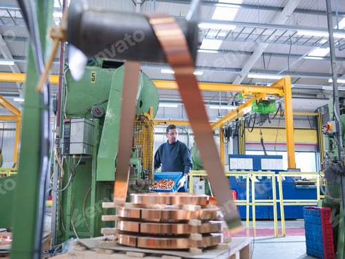 Preview: Worker operating copper punching machine in engineering factory