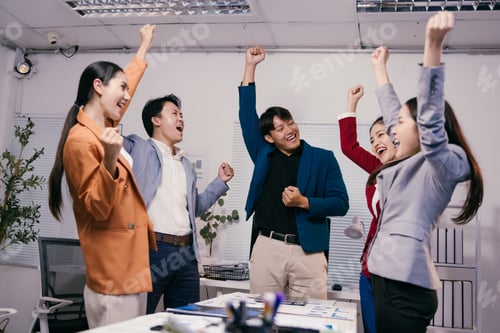 Preview: Euphoric businesspeople are raising their arms and cheering, expressing joy and teamwork after achie