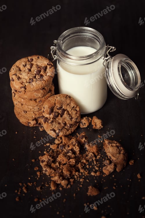 Preview: Homemade chocolate chip cookies with bottle of milk and crumbs