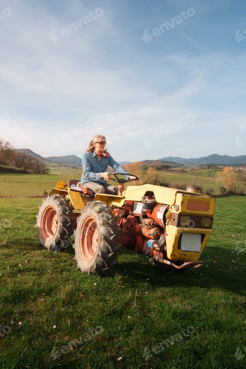 Preview: Farmer woman driving tractor in green field celebrating international workers' day