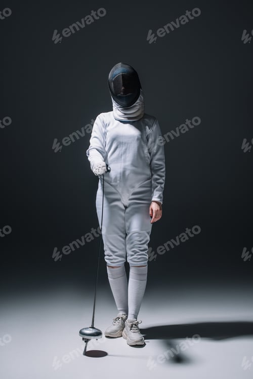 Preview: Fencer in fencing mask holding rapier on black background