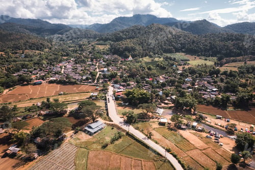 Preview: Tranquil local village with river flowing through among the valley and rice plantation on dry season