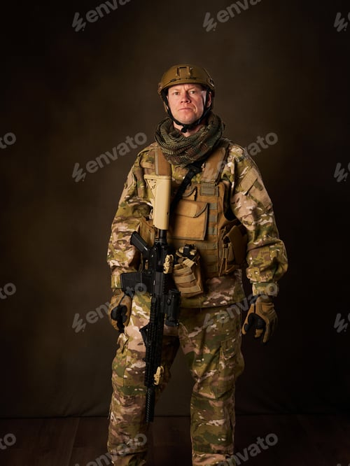 Preview: a young military soldier with automatic airsoft rifle with telescopic vision