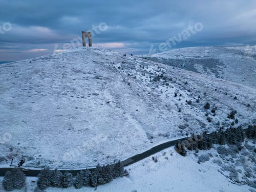 Preview: Beautiful aerial view of snow covered mountains and the Monument Arch of Liberty at the main ridge