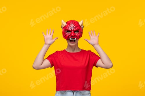 Preview: young female wearing scary devil mask yellow background cartoon halloween