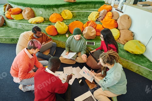 Preview: Group of young intercultural financial managers in casualwear discussing papers