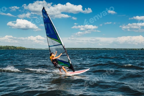 Preview: the athlete rides the windsurf over the waves on the lake