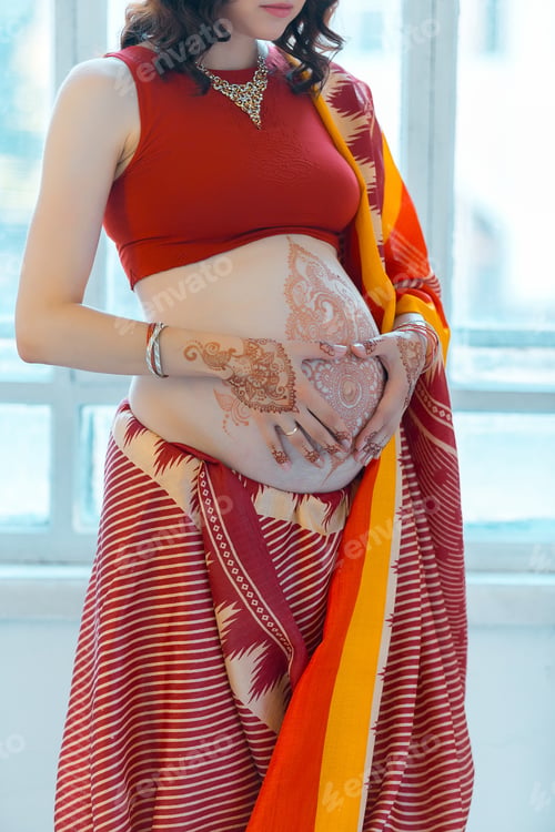 Preview: Indian Picture On Woman Hands And Pregnant Belly With Henna Tattoo On White Room Background