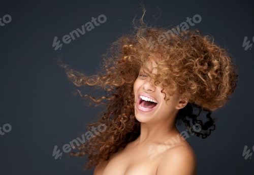 Preview: Portrait of a happy young woman laughing with hair blowing