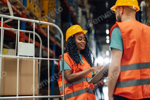 Preview: Warehouse workers using digital tablet and discussing logistics