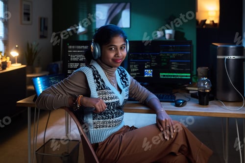 Preview: Portrait of Young South Asian Woman Listening to Music While Programming