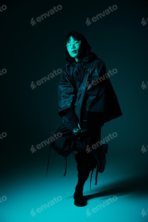 Preview: Stylish asian man posing in a dramatic blue illuminated space showcasing modern fashion