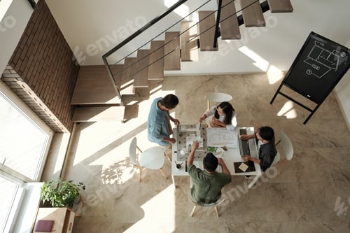 Aperçu: Group of young Chinese architects gathered by table for discussion of new project