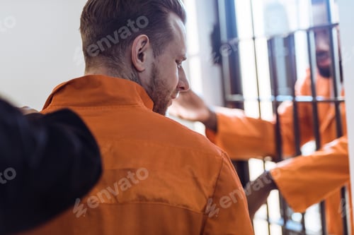 Preview: cropped image of prison guard leading criminal