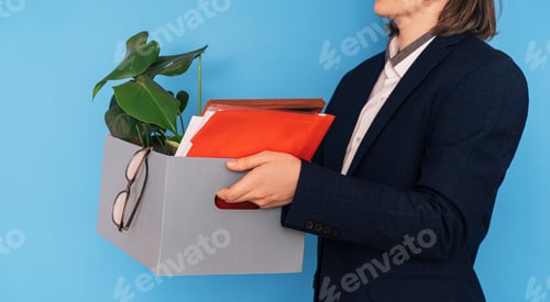 Preview: Girl in white shirt and jacket holding box with office supplies and flower in her hands