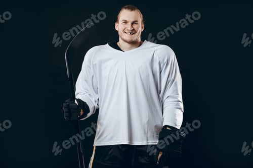 Preview: Handsome hockey player. Smiling at camera isolated on black background.