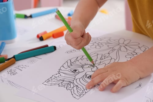 Preview: Child coloring drawing at table in room, closeup