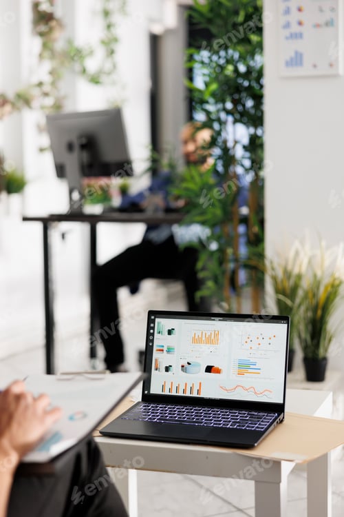 Preview: Employee reviewing sales data on laptop screen, budgeting strategy