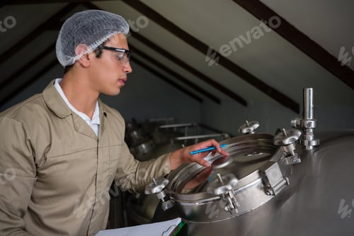 Preview: Worker examining storage tank