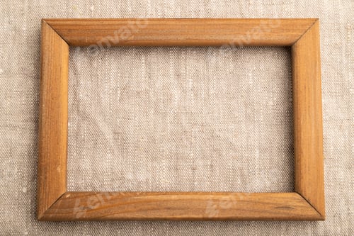 Preview: Wooden frame on smooth white linen tissue. Top view, natural textile background.