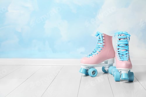 Preview: Vintage roller skates on floor near color wall. Space for text
