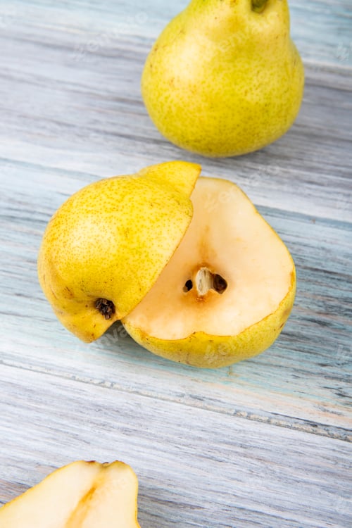 Preview: side view of fresh green pear and pear halves on wooden background