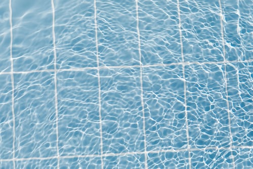 Preview: Clear water surface with ripple wave splashes and drops in swimming pool. Abstract turquoise