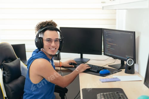 Preview: Young male programmer in casual clothes working on the computer at the table.