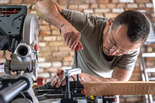 Preview: Professional carpenter working with a miter saw.
