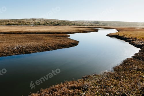 Preview: The open spaces of marshland and water channels. Flat calm water.