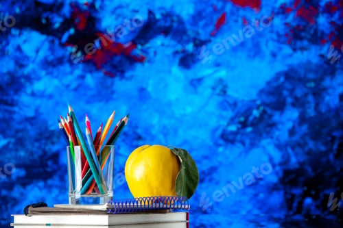 Preview: Front close view of colored pencils kept in a glass jar and quince with stem on stacked spiral