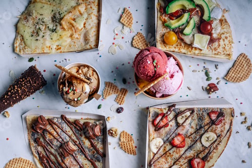 Preview: Aerial view of variety of crepes and ice creams on table