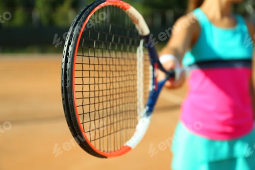 Preview: Sportswoman playing tennis at court on sunny day, closeup