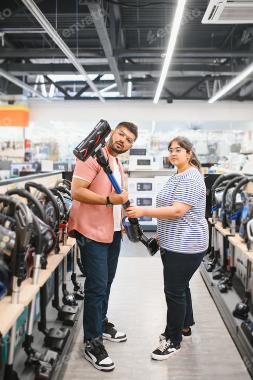 Preview: A young Indian couple buys a vacuum cleaner at an electronics store