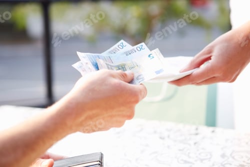 Preview: Man paying with Euro notes in a pavement cafe