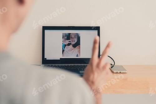 Preview: Woman in picture or video chat on monitor laptop smiling face and two fingers is fighting.