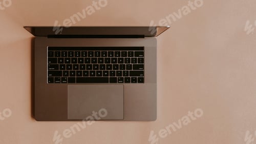 Preview: Laptop lying on a peach background