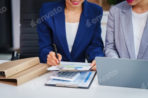 Preview: Two Asian businesswomen collaborate on stock market strategies and financial services, exchanging