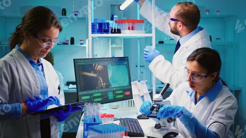 Preview: Team of positive scientists working in chemistry laboratory