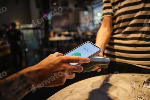 Preview: Person uses their smartphonee to pay at a food establishment